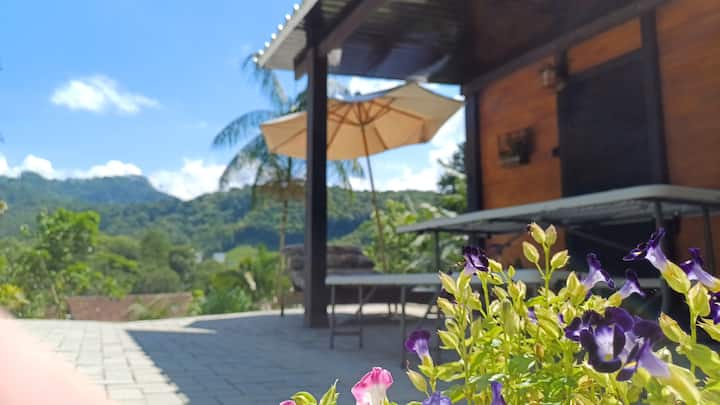 Deck externo da Cabana Angillyn com guarda-sol e flores